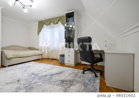 Interior of a large brightly lit comfortable bedroom with single bed Interior of a large brightly lit comfortable bedroom with single bed 98031602