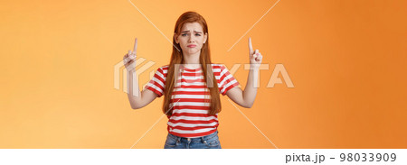 Disappointed upset cute whining timid redhead girl, gloomy face, pulling sad expression, complain, crying feeling regret loss, losing lottery, pointing up displeased, show despair and sorrow emotion Disappointed upset cute whining timid redhead girl, gloomy face, pulling sad expression, complain, crying feeling regret loss, losing lottery, pointing up displeased, show despair and sorrow emotion 98033909