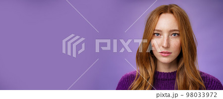 Headshot of sensual and attractive tender redhead female with freckles and pure skin looking at camera focused and sincere with slightly opened mouth, posing against purple background Headshot of sensual and attractive tender redhead female with freckles and pure skin looking at camera focused and sincere with slightly opened mouth, posing against purple background 98033972