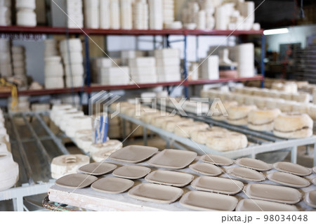 Shelves with unfinished ceramic dishware in pottery factory 98034048