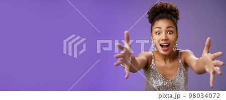 Amused elegant woman looking desire extend arms widen eyes impressed gasping extend arms towards camera hug give embrace cannot resist temptetion standing blue background 98034072