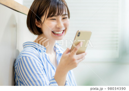 スマホを操作する若い女性 98034390