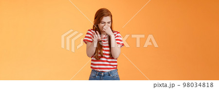 Gosh it stinks. Reluctant disgusted redhead woman raise hand block dislike gesture shut nose, cringe from aversion dislike, puke from reek bad smell, stand orange background disappointed Gosh it stinks. Reluctant disgusted redhead woman raise hand block dislike gesture shut nose, cringe from aversion dislike, puke from reek bad smell, stand orange background disappointed 98034818
