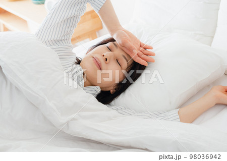 起床時に不調を感じるミドル女性 98036942