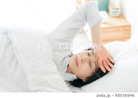 起床時に不調を感じるミドル女性 98036946