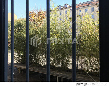 イタリアのマンションの一室。大きな縦サッシの窓に明るい晴れた外の風景画写る画像。 98038820