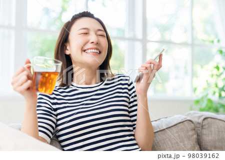 スマホを見る女性 笑顔 スマホを見る女性 笑顔 98039162