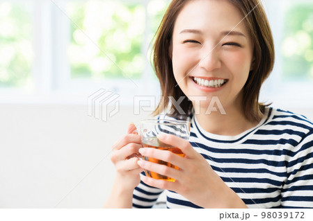部屋でリラックスする若い女性　飲み物 98039172