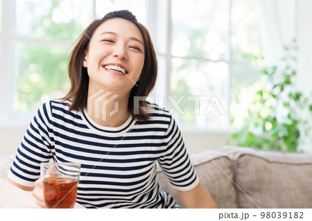 部屋でリラックスする若い女性　飲み物 98039182