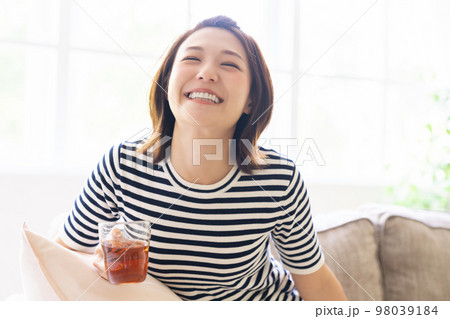 部屋でリラックスする若い女性　飲み物 98039184