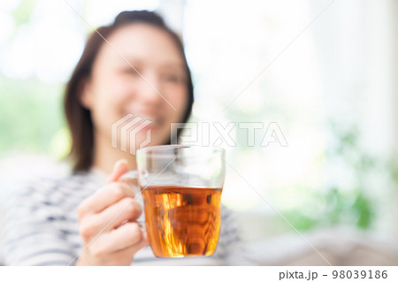 部屋でリラックスする若い女性　手元　飲み物 98039186