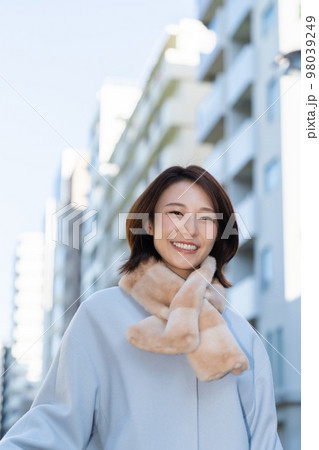 コートを着た笑顔の女性 98039249