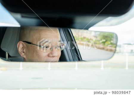 車のルームミラーに映る男性 98039847