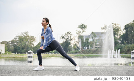 Healthy Asian woman in sportswear stretching her legs, getting ready to run at the city park. Healthy Asian woman in sportswear stretching her legs, getting ready to run at the city park. 98040453