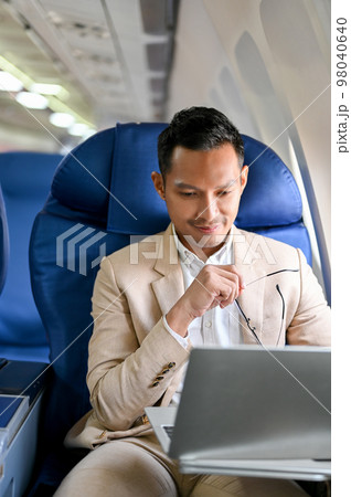 Portrait, Professional Asian businessman using a laptop during the flight for his business trip. Portrait, Professional Asian businessman using a laptop during the flight for his business trip. 98040640