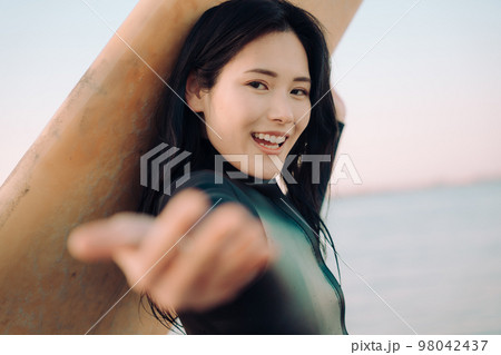 サーフィンを楽しむ若い女性 98042437