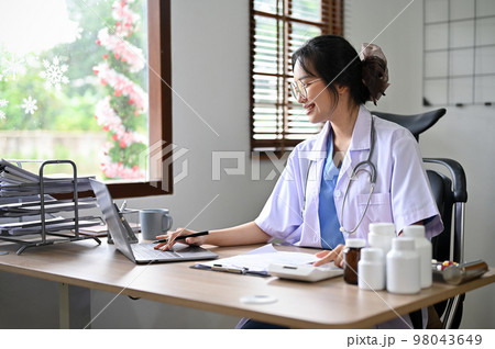 Attractive Asian female doctor using calculator and laptop, estimating surgery cost for her patient Attractive Asian female doctor using calculator and laptop, estimating surgery cost for her patient 98043649