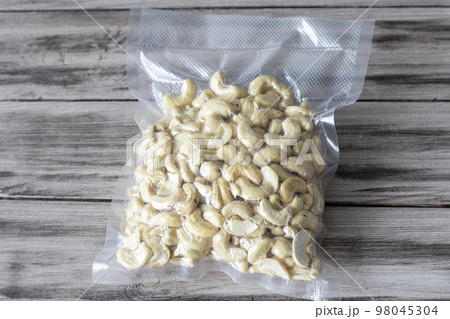 Vacuum-packed dried cashews on a wooden background. Plant-based diet, healthy fats, keto diet, lchf 98045304
