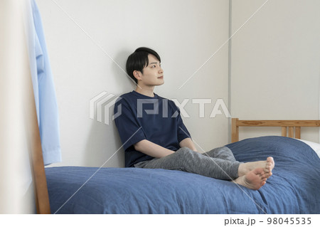 ベッドの上に座った若い男性 ベッドの上に座った若い男性 98045535