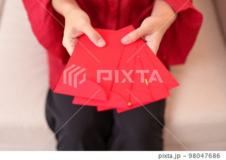 Woman holding Chinese red envelope, money gift for happy Lunar New Year holiday Woman holding Chinese red envelope, money gift for happy Lunar New Year holiday 98047686