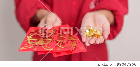 Woman holding Chinese red envelope with gold bullion, money gift for happy Lunar New Year holiday. Chinese sentence means happiness, healthy, Lucky and Wealthy 98047806