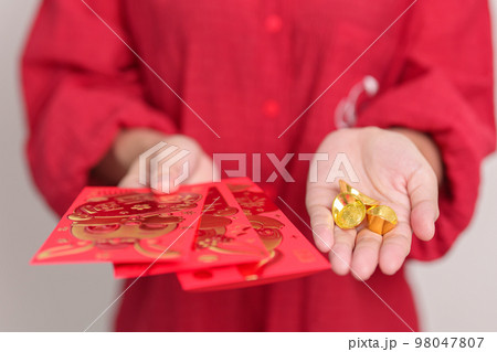 Woman holding Chinese red envelope with gold bullion, money gift for happy Lunar New Year holiday. Chinese sentence means happiness, healthy, Lucky and Wealthy 98047807