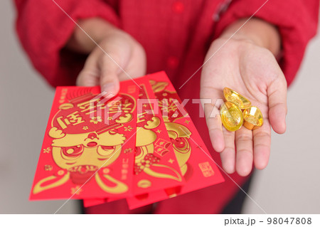 Woman holding Chinese red envelope with gold bullion, money gift for happy Lunar New Year holiday. Chinese sentence means happiness, healthy, Lucky and Wealthy 98047808
