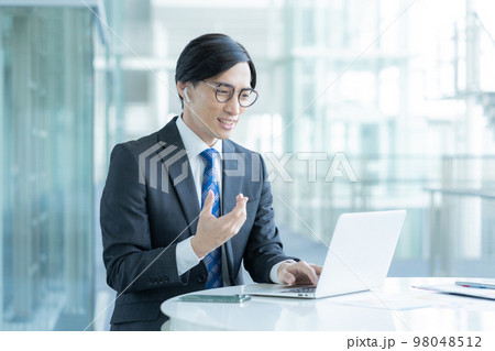 ビジネス ビデオ通話をするメガネをかけたビジネスマン ビジネス ビデオ通話をするメガネをかけたビジネスマン 98048512