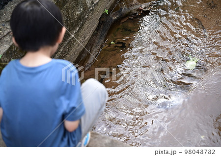 a boy looking stream water a boy looking stream water 98048782