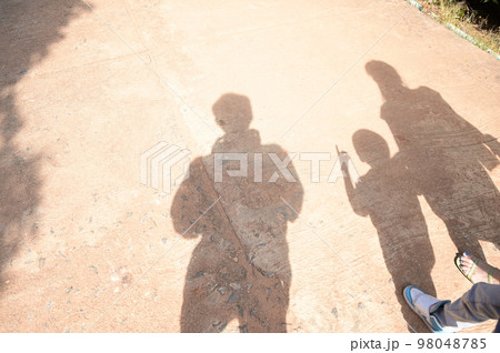 shadow of family on the road 98048785