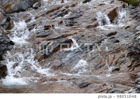 Beautiful texture of black-brown granite, saturated with various shades of minerals included in it Beautiful texture of black-brown granite, saturated with various shades of minerals included in it 98051048