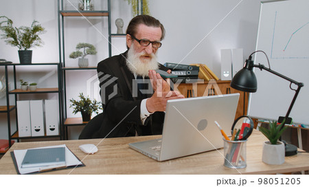 Senior business man working, having mobile phone talk at office workplace using messenger chat apps Senior business man working, having mobile phone talk at office workplace using messenger chat apps 98051205