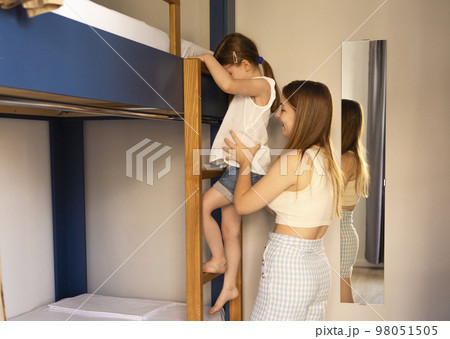 Caucasian siblings by bunk bed. Older sister helping. Caucasian siblings by bunk bed. Older sister helping. 98051505