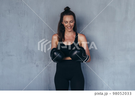 Portrait of young sportswoman in boxing gloves. Portrait of young sportswoman in boxing gloves. 98052033