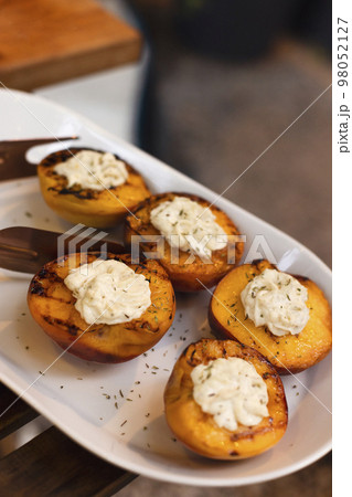 Grilled tasty cut peaches, served with whipped cheese cream, closeu 98052127