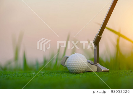 Golf clubs and golf balls on a green lawn in a beautiful golf course. Golf clubs and golf balls on a green lawn in a beautiful golf course. 98052326