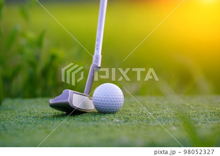 Golf clubs and golf balls on a green lawn in a beautiful golf course. 98052327