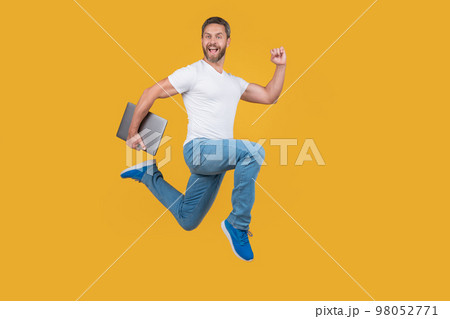 man running with laptop has deadline. Happy man midair yellow background. man running with laptop has deadline. Happy man midair yellow background. 98052771