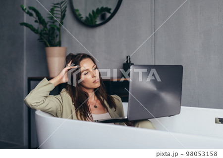Woman secluded at home in the bathroom and works 98053158