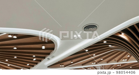 Ceiling mounted cassette type air conditioner and modern lamp light on white ceiling. Duct air conditioner for home, hall or office. 98054406