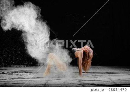 Young slim woman with spread flour on the air 98054479