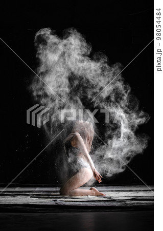 Young slim woman with spread flour on the air 98054484