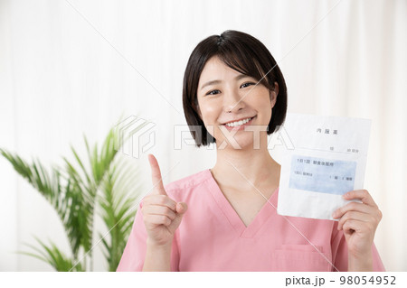 お薬手帳と薬袋を持つ薬剤師 98054952