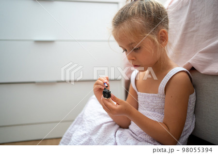 Little girl make ceramic decor sitting floor 98055394