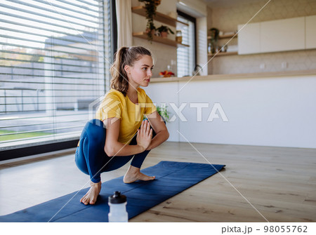 Young woman doing an exercises at home. 98055762
