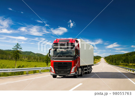 Red truck on a road in summer 98055763