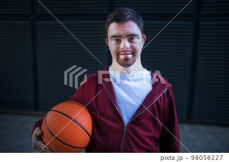 Portrait of young man with down syndrom holding basketball ball. Portrait of young man with down syndrom holding basketball ball. 98056227