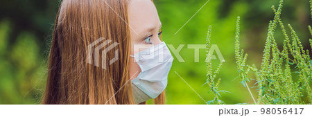Young woman in a medical mask because of an allergy to ragweed BANNER, long format Young woman in a medical mask because of an allergy to ragweed BANNER, long format 98056417