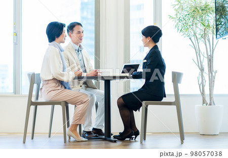 ミドルの夫婦に営業するビジネスウーマン ミドルの夫婦に営業するビジネスウーマン 98057038