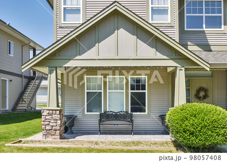 Facade of family house with casted bench at the window beside the entrance 98057408